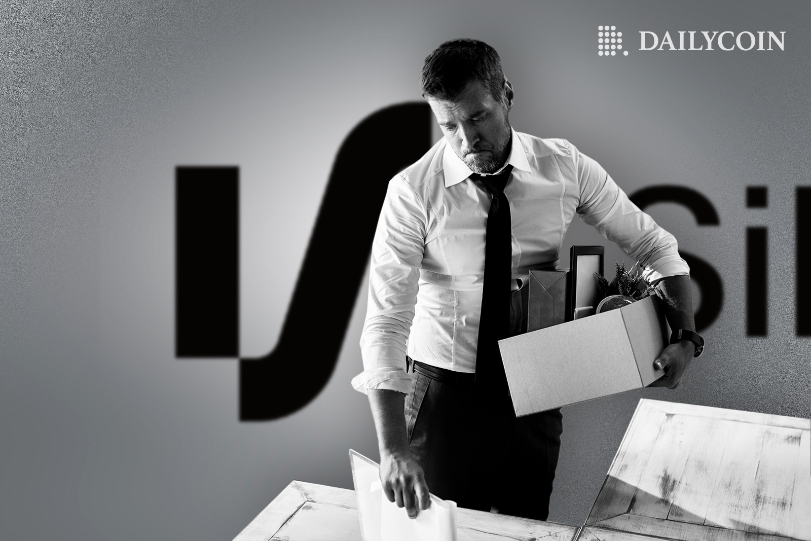 A guy packing up his stuff from the office in front of Crypto Bank Silvergate logo.
