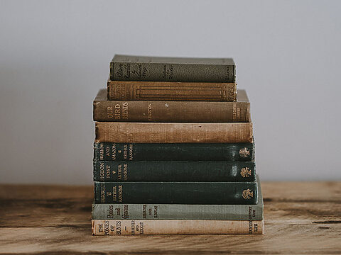 annie-spratt-gl7joOaABlI-unsplash Old books stacked on the table.