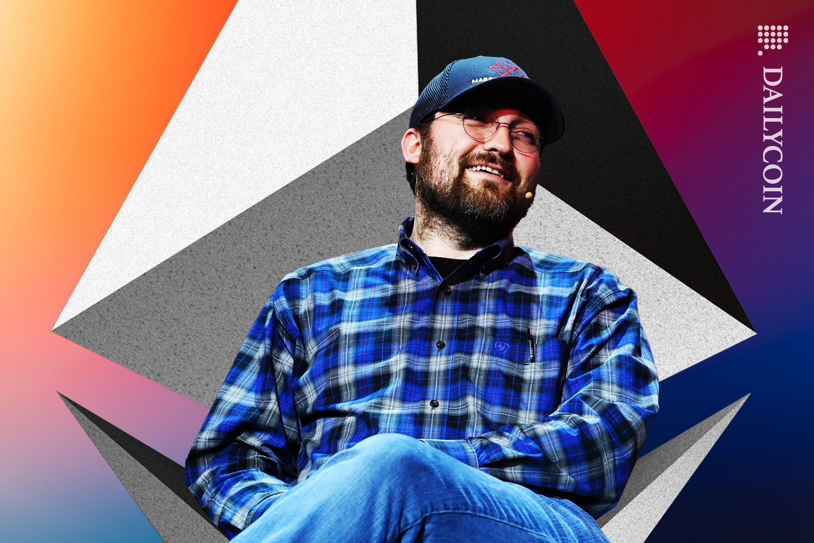 Charles Hoskinson smiling while sitting on Ethereum 3D logo chair.