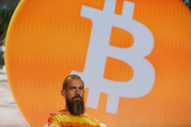 Jack Dorsey at bitcoin conference in front of a screen showing a giant Bitcoin.