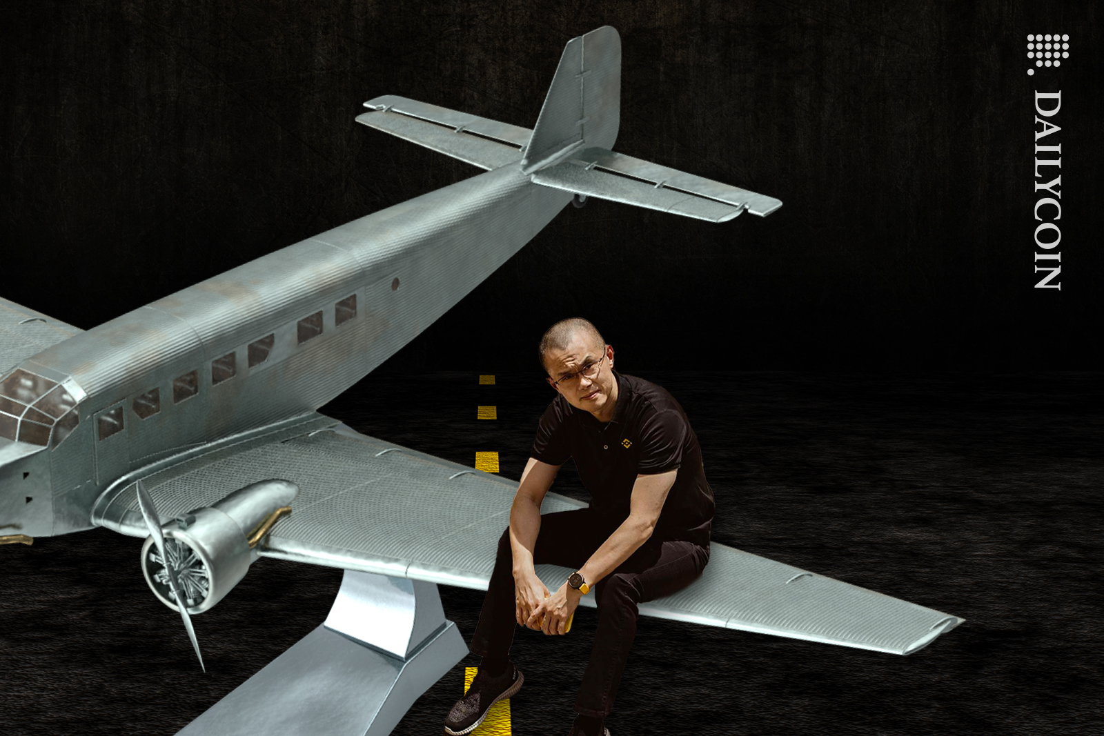Changpeng Zhao sitting on a plane wing looking up.