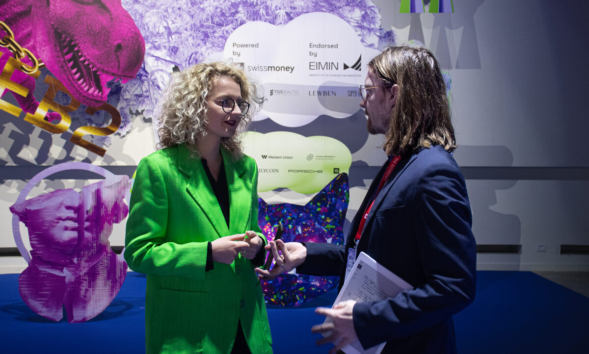 Two humans talking to each other at a conference.