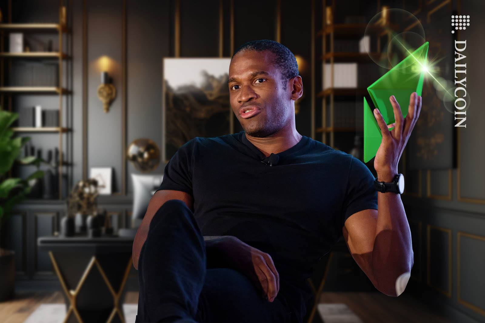 Arthur Hayes sitting in his office holding up a green Ethereum logo.