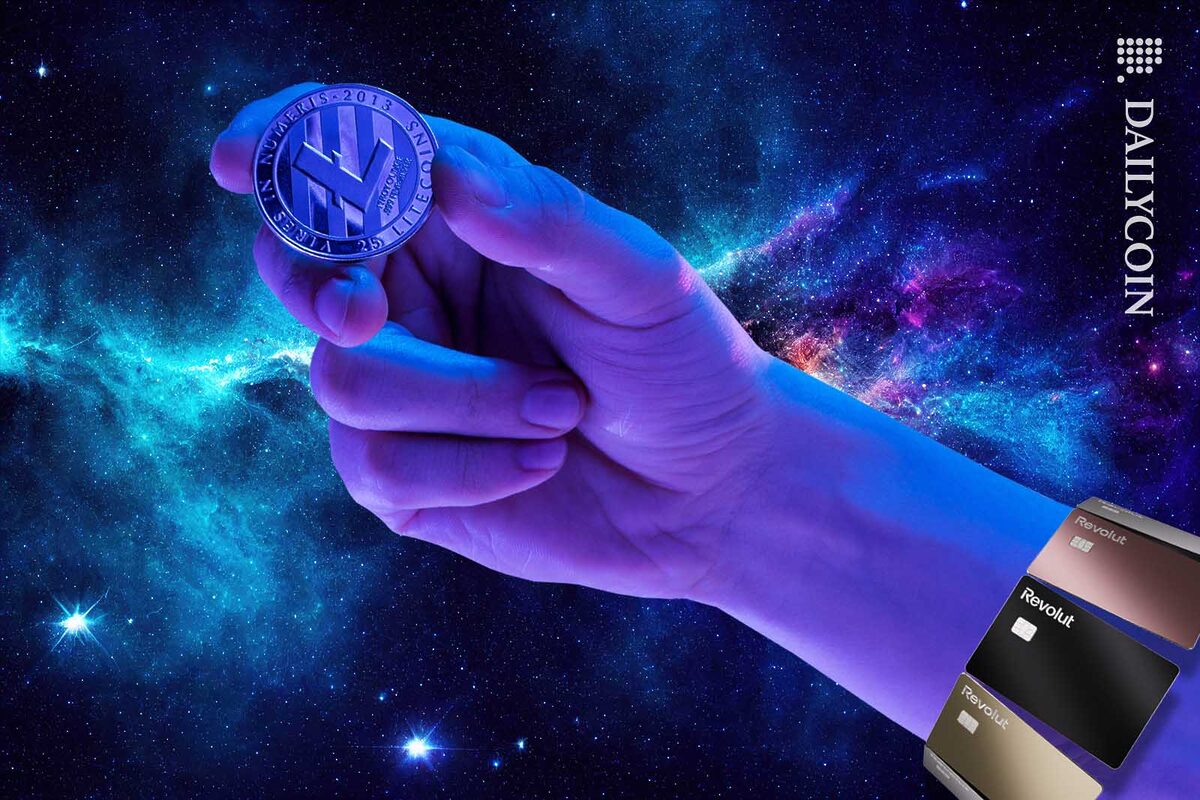 Hand holding a Lite coin surrounded by Revolut cards.