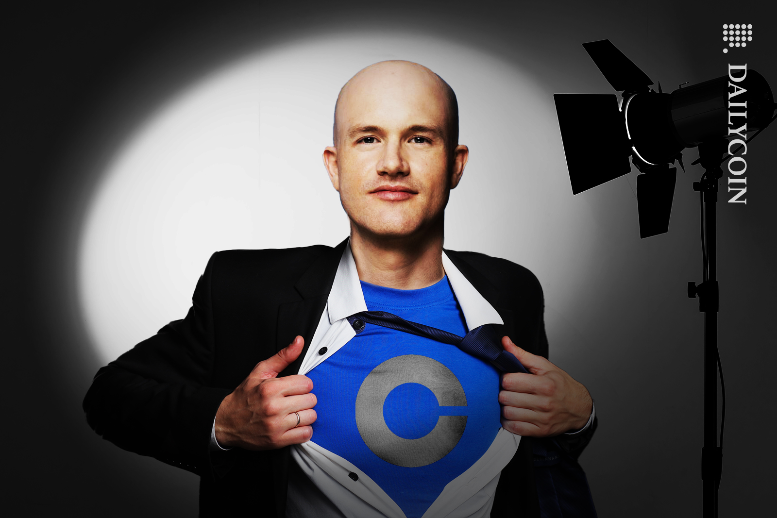 Brian Armstrong proudly shows of his Coinbase t-shirt under his shirt.