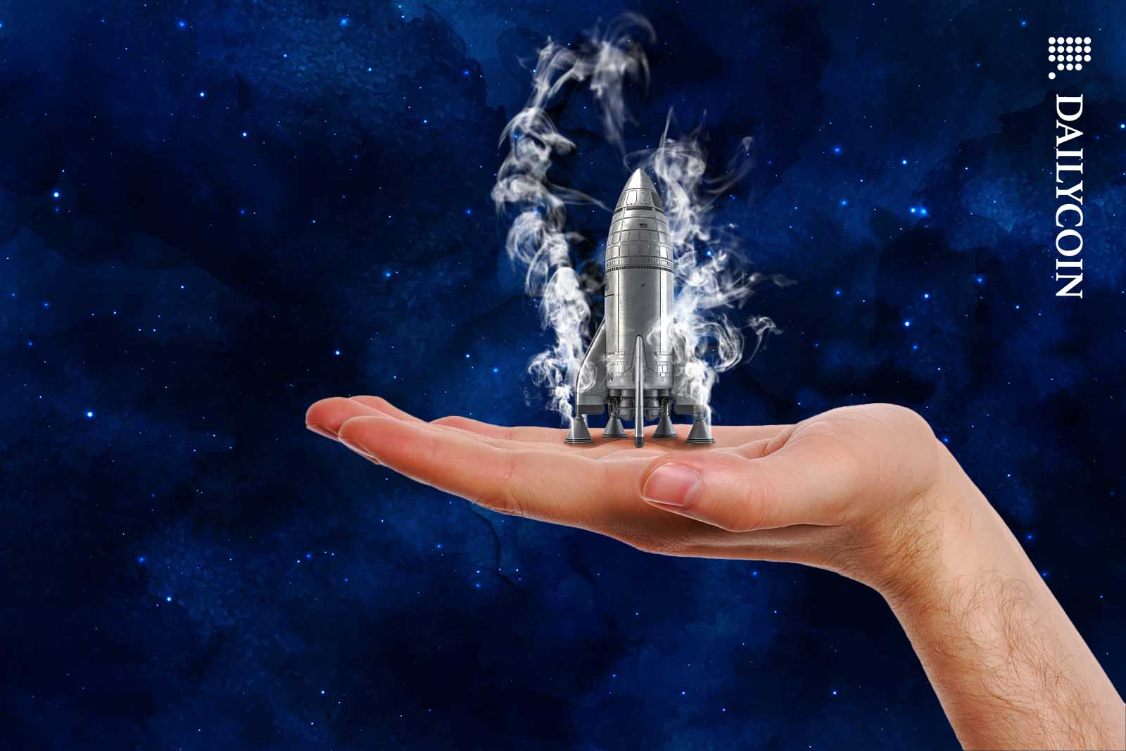 Little rocked on human hand being ready to be launched.