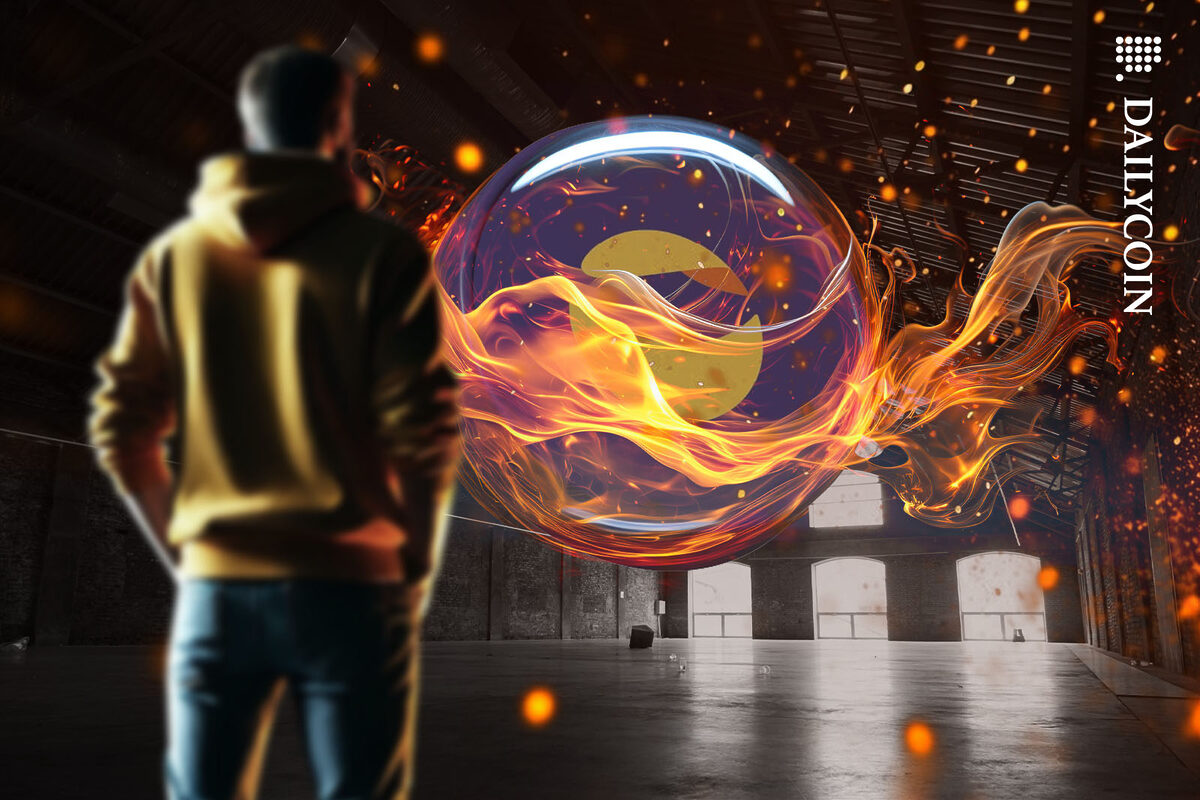 A man in a yellow hoodie watching a fireball levitating in the middle of a warehouse.