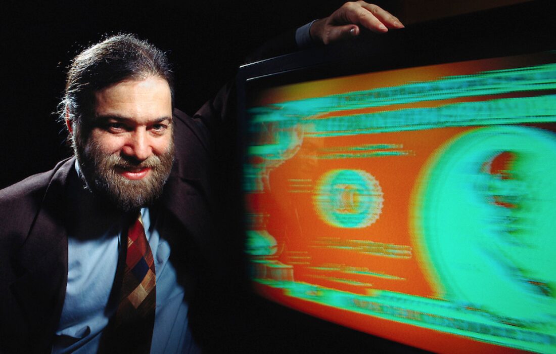 A young David Chaum with his hand resting on a giant digital illustration of eCash.