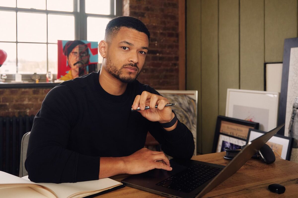 Steven Bartlett of Diary of a CEO looking at the camera with a pen in one hand and a laptop in front of him.