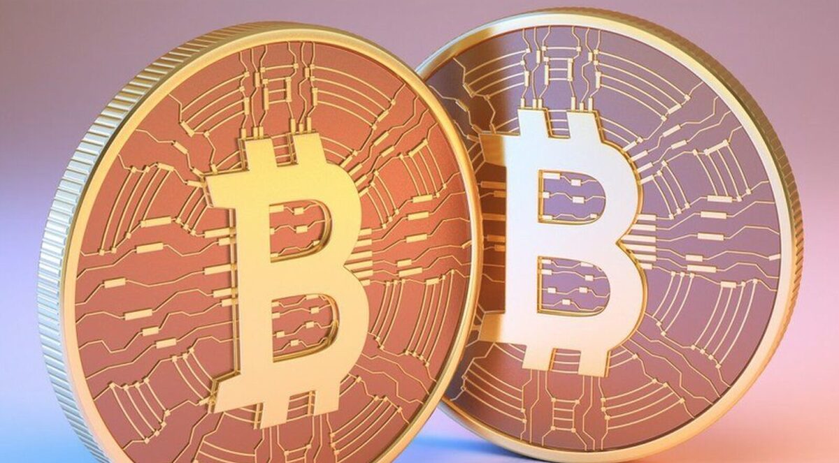 Two golden and bronze Bitcoin coins next to one another.