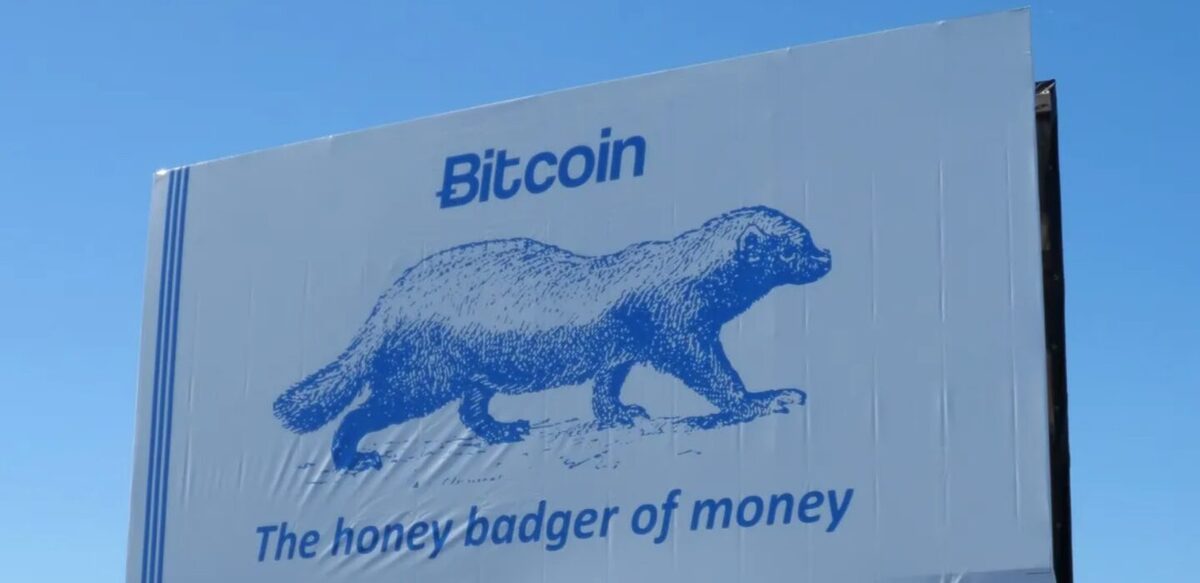 A billboard with a honeybadger in the centre and the words "Bitcoin, the honey badger of money" written around it.