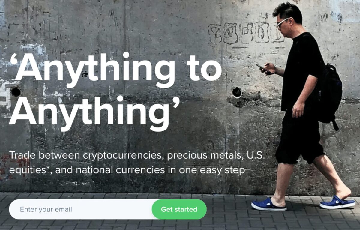 A man walking while looking at his phone with the slogan 'Anything to Anything' referring to how multiple assets can be traded on Uphold.