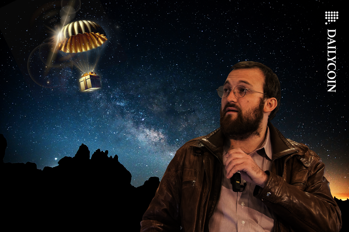 Charles Hoskinson looking up the sky at a golden parachute at midnight.