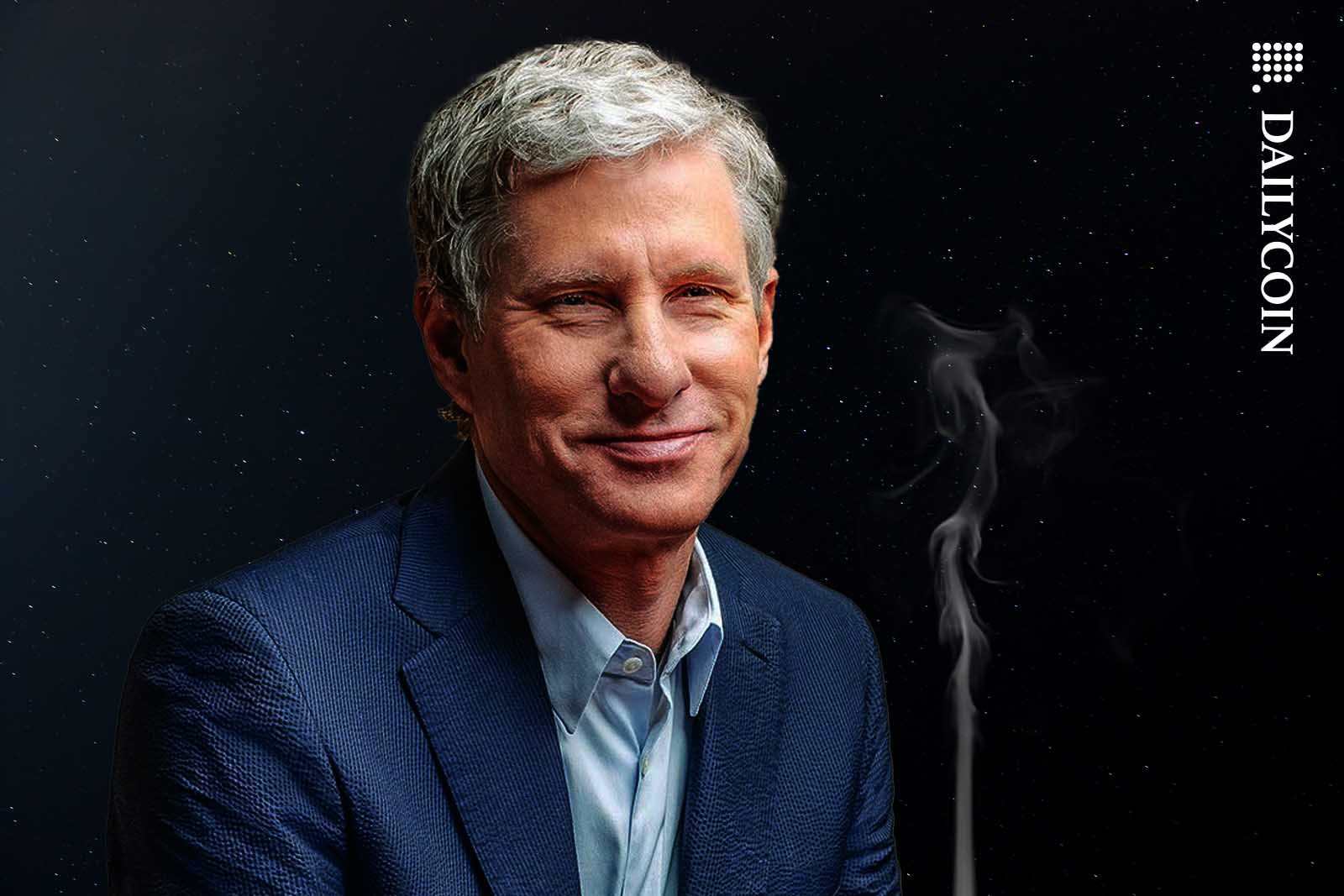 Chris Larsen smiling as smoking outside under the stars.