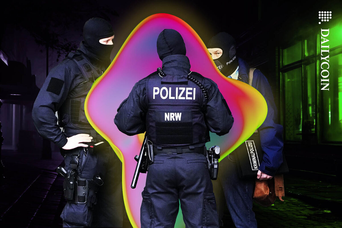 German police officers surrounding an unidentified colourful object.