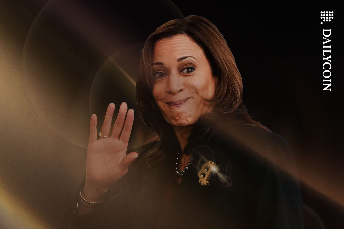 Kamala Harris smiling for the camera with a Bitcoin brioche the wrong way around on her blazer.