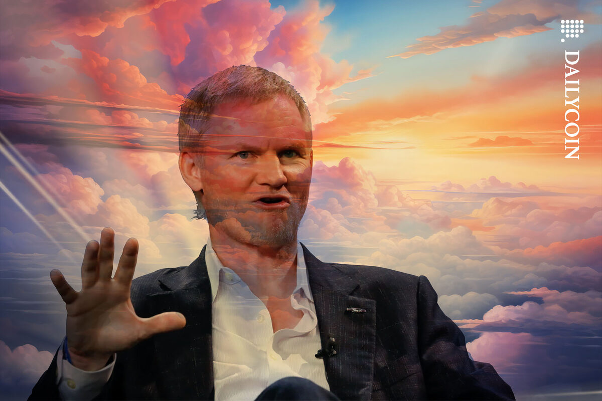 Mike Belshe talking confidently in front of a colouful sky.