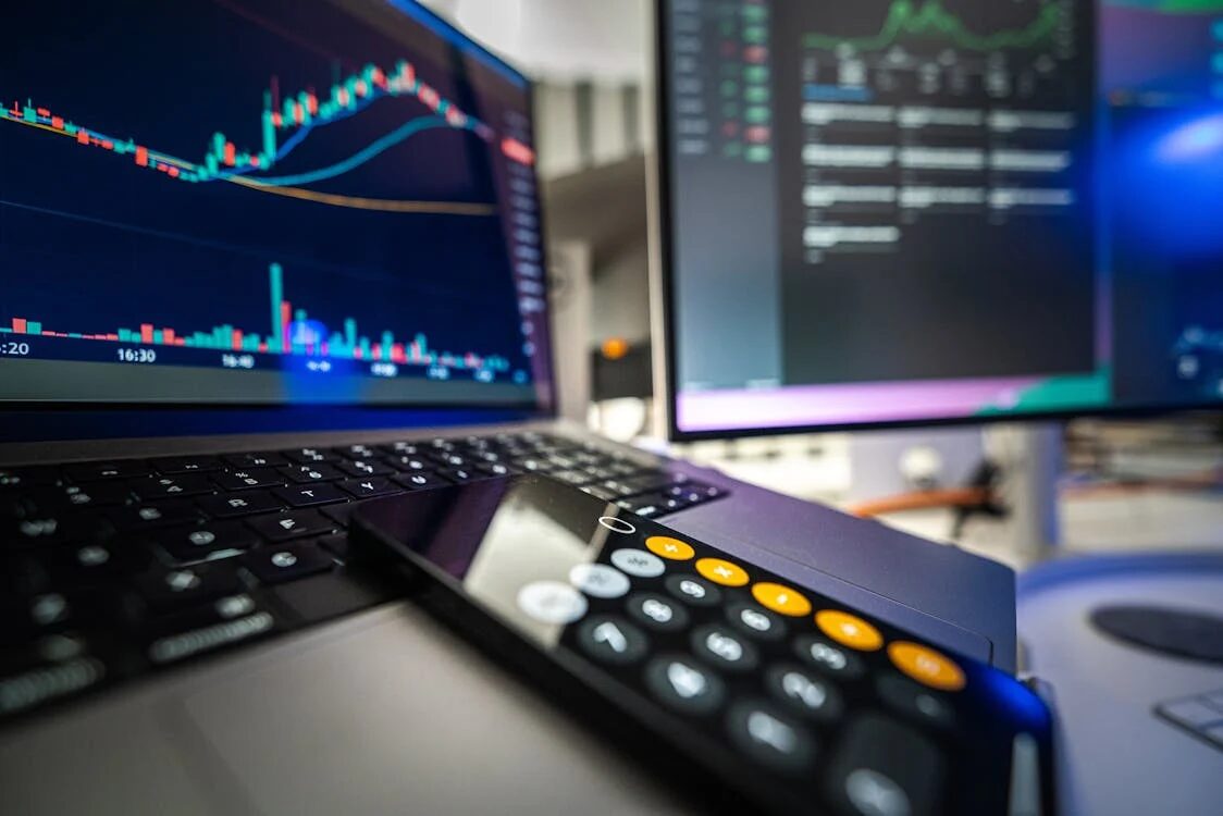 Close up shots of a phone and a computer with investment tools.