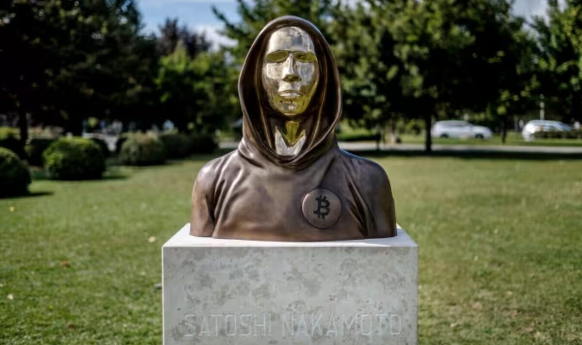 Bust of Satoshi Nakamoto showing a man with a brown hoodie and a Bitcoin badge on his hoodie.