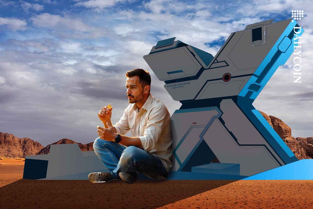 Man in desert looking at a coin sitting next to a large HTX X.