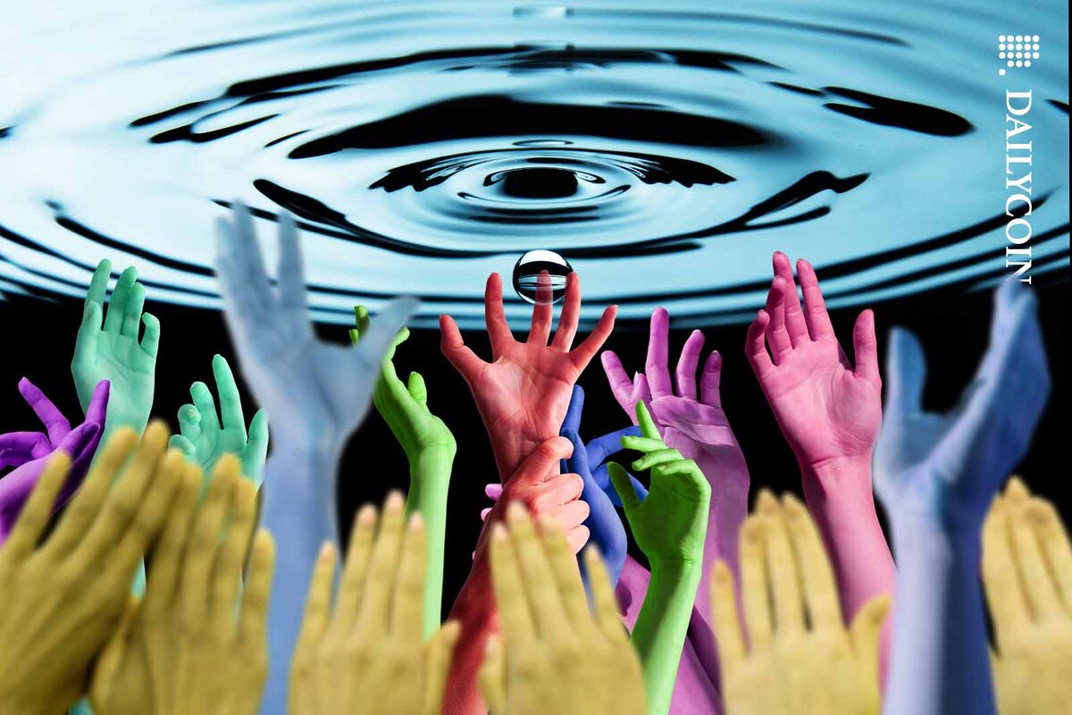 Many colorful hands reaching up towards a water ripple.