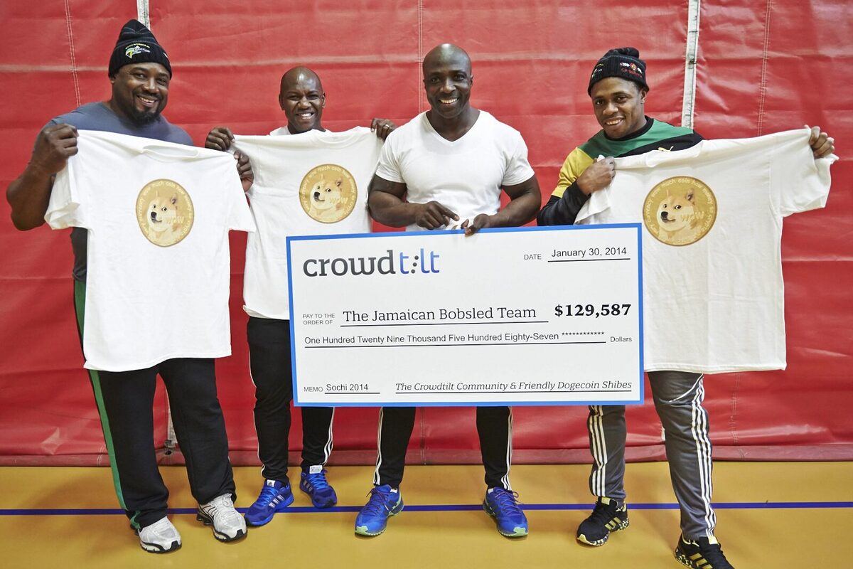 Jamaican Bobsled Team holding up a $129,587 check donated from the DOGE community, along with shirts with the Dogecoin logo at the centre.