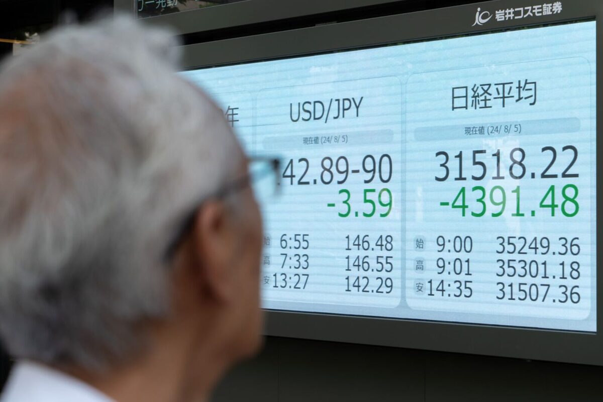 Man looking at a stock market chart showing a decline in the USD and Japanese stocks during the August crash.