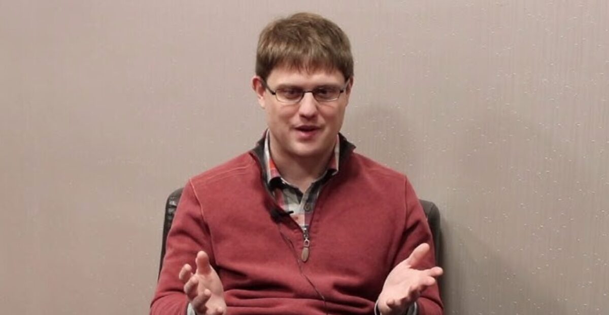 Peter Todd in a red fleece jacket talking to the camera.