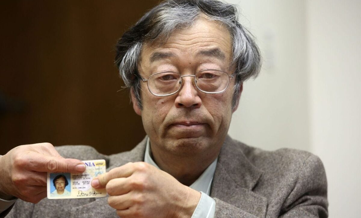Dorian Nakamoto holding up his password but while covering the top to hide details.