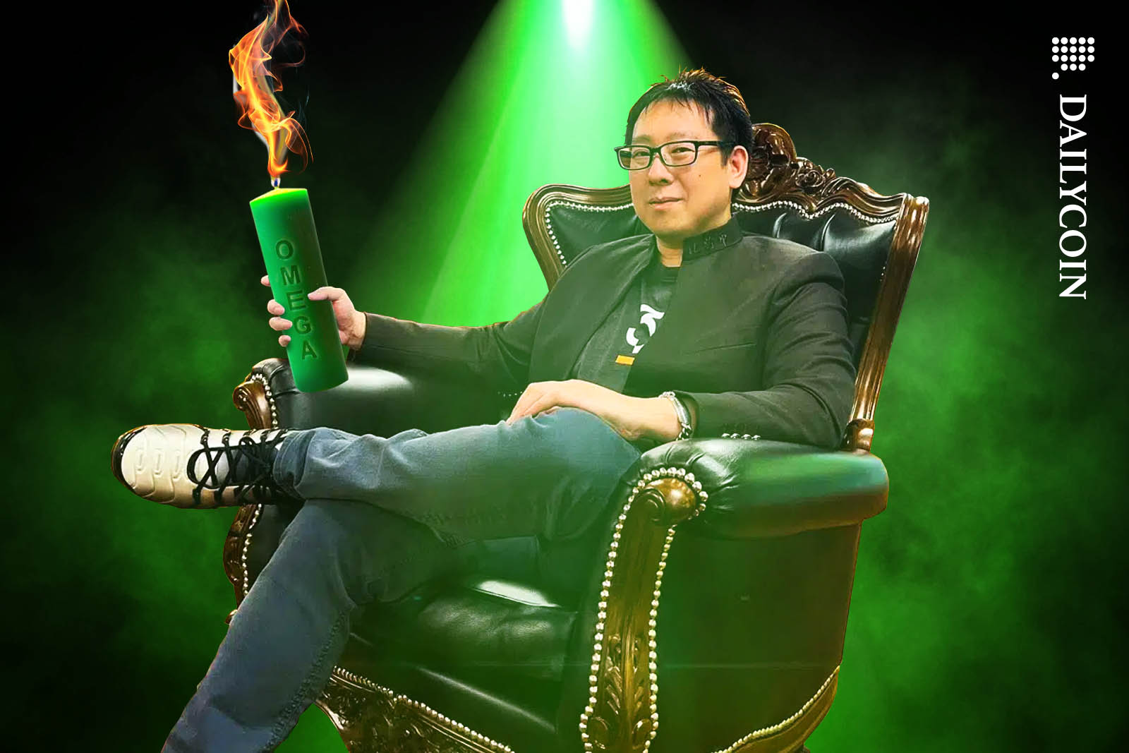 Samson Mow sitting in an armchair holding a green Omega candle.